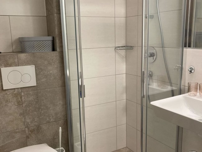 Badezimmer mit Waschbecken, Dusche und WC